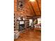 Inviting living room with stone fireplace and wood-paneled walls and ceiling with hardwood floor at 6503 Old Macon Hwy, Rex, GA 30273