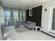 Bright sunroom featuring large windows with sheer curtains, a cozy sofa, and brick accent wall at 1379 Pair Sw Rd, Marietta, GA 30008