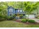 Charming blue two-story home with a yellow door, white trim, and lush landscaping at 2317 Danielle Ct, Marietta, GA 30062
