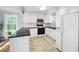 A well-lit kitchen showcasing white cabinetry, black countertops, stainless steel appliances, and a large window at 2317 Danielle Ct, Marietta, GA 30062