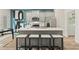 Close-up view of a modern kitchen featuring a gray island, quartz countertop and stainless appliances at 400 Brooch Way, Stockbridge, GA 30281