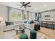 Open-concept living room with natural light, modern furnishings, and eat-in kitchen at 400 Brooch Way, Stockbridge, GA 30281