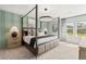 Bright bedroom with a four-poster bed, accent wall, and large windows at 400 Brooch Way, Stockbridge, GA 30281