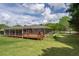 Exterior view of the house showcasing the wooden deck and spacious, well-maintained backyard at 220 Pitts Chapel Rd, Newborn, GA 30056