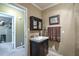 Charming bathroom featuring a dark vanity, decorative mirror, and complementary towel at 220 Pitts Chapel Rd, Newborn, GA 30056