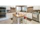 Bright kitchen with an island, white cabinets, and stainless steel appliances at 220 Pitts Chapel Rd, Newborn, GA 30056