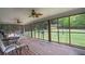 Spacious screened-in porch featuring a wooded view, ceiling fans, and comfortable seating at 220 Pitts Chapel Rd, Newborn, GA 30056
