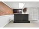 Basement bar featuring a granite counter, brick accent wall, and cabinetry at 2667 Fieldstone Se Dr, Conyers, GA 30013