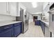 Well-lit kitchen with stainless steel appliances, white upper cabinets, and blue lower cabinets for storage at 2667 Fieldstone Se Dr, Conyers, GA 30013