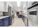 Modern kitchen boasts stainless steel appliances, white cabinets, and blue island overlooking the living space at 2667 Fieldstone Se Dr, Conyers, GA 30013