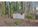 Outdoor storage shed situated in a backyard surrounded by trees and foliage at 2667 Fieldstone Se Dr, Conyers, GA 30013