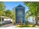 Charming blue two-story home with inviting front porch nestled among lush green trees on a sunny day at 281 Griffin Nw St, Atlanta, GA 30314