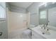 Classic bathroom featuring a shower and tub combination, single sink vanity, and a large window at 4320 Royal Mustang Way, Snellville, GA 30039