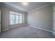 A room featuring neutral walls and carpet, complemented by natural light streaming through the bright window at 4320 Royal Mustang Way, Snellville, GA 30039