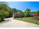 A charming brick two-story home boasts a well-manicured lawn and long drive under a clear blue sky at 4320 Royal Mustang Way, Snellville, GA 30039