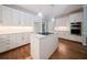 A bright kitchen featuring white cabinets, stainless steel appliances, subway tiles, an island, and hardwood floors at 4320 Royal Mustang Way, Snellville, GA 30039