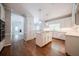 Bright kitchen featuring white cabinetry, hardwood floors, a center island, and stainless steel appliances at 4320 Royal Mustang Way, Snellville, GA 30039