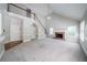 A spacious living room featuring carpeted floors, a fireplace, and an adjoining staircase to the second level at 4320 Royal Mustang Way, Snellville, GA 30039