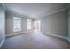 Sunlit living room with two windows, neutral walls, and plush carpeting at 4320 Royal Mustang Way, Snellville, GA 30039