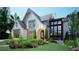 A beautifully landscaped home with a painted brick facade, arched entryway, and modern windows at 469 Emily Reed Ln, Atlanta, GA 30342