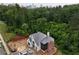 New construction home with gray roof and brick accents surrounded by lush green trees and a city skyline in the background at 469 Emily Reed Lot 11 Ln, Atlanta, GA 30342