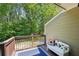 Cozy back porch with wood railing, outdoor rug, and a charming white bench with a sunflower pillow at 734 Frasier Se Cir, Marietta, GA 30060