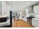 Bright kitchen features stainless appliances, white cabinetry, and hardwood floors leading to the living area at 734 Frasier Se Cir, Marietta, GA 30060