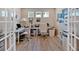 This office space features French doors, hardwood floors, white furniture, and multiple paintings at 127 Laurel Farms Ln, Dallas, GA 30157
