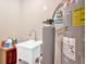 This room includes a Rheem hot water tank, a utility sink, and neutral paint at 127 Laurel Farms Ln, Dallas, GA 30157