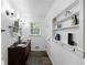 Well-lit bathroom featuring a double sink vanity, shelving, and elegant decor at 1391 Arden Sw Dr, Marietta, GA 30008