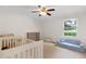 Bright bedroom with a ceiling fan, window views, and cozy seating for a play area at 1391 Arden Sw Dr, Marietta, GA 30008