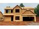 Unfinished two-story home exterior showing the framework and initial stages of construction, including the garage at 492 Charleston Pl, Villa Rica, GA 30180