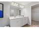 Bathroom featuring a double vanity, white cabinetry, and a large mirror with modern lighting at 8214 Tiger Way, Riverdale, GA 30296