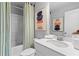 Bright bathroom featuring a shower-tub combo, modern vanity, and tasteful abstract art at 8214 Tiger Way, Riverdale, GA 30296
