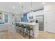 Open-concept kitchen with island seating, stainless steel appliances, and contemporary lighting at 8214 Tiger Way, Riverdale, GA 30296