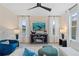 Bright living room featuring large windows, modern ceiling fan, and stylish decor at 8214 Tiger Way, Riverdale, GA 30296