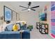 Stylish living room featuring a blue sectional sofa, colorful decor, and a modern ceiling fan at 8214 Tiger Way, Riverdale, GA 30296
