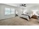 Inviting bedroom with a ceiling fan, carpet, and bright natural light from the windows at 113 Courtyard Ter, Roswell, GA 30075