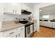 Well-lit kitchen featuring white cabinets and granite countertops, view to the living room at 113 Courtyard Ter, Roswell, GA 30075