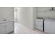 Bright laundry room with washer, dryer, sink, cabinets, and tiled floor at 1584 Fernstone Nw Cir, Acworth, GA 30101