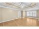 Spacious primary bedroom featuring hardwood floors, tray ceiling, and plantation shutters at 1584 Fernstone Nw Cir, Acworth, GA 30101