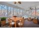 Enclosed porch with dining table and wicker furniture, with a view of the surrounding trees at 1584 Fernstone Nw Cir, Acworth, GA 30101
