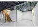 Unfinished basement space with open ceiling, wooden stairs, and concrete floor at 1652 Detroit Nw Ave, Atlanta, GA 30314