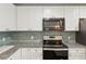 Granite countertops and subway tile backsplash highlight stainless steel appliances at 1652 Detroit Nw Ave, Atlanta, GA 30314