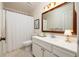 Well-lit bathroom featuring a white vanity with cabinets, a framed mirror, and a shower with a curtain at 266 Adair St, Decatur, GA 30030