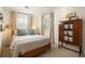 A cozy bedroom with neutral tones, a wooden bed frame, and natural light streaming through shuttered windows at 266 Adair St, Decatur, GA 30030