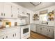 Charming kitchen features white appliances, marble countertops, and open shelving for added storage at 266 Adair St, Decatur, GA 30030