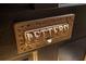 Close-up of an ornate metal mail slot on a dark wood door with the word 