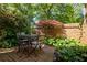 Secluded brick patio features a glass-top table, four chairs, and lush greenery, perfect for outdoor relaxation at 266 Adair St, Decatur, GA 30030