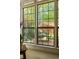 Large windows offer a view of the brick patio with a table and four chairs surrounded by lush foliage at 266 Adair St, Decatur, GA 30030
